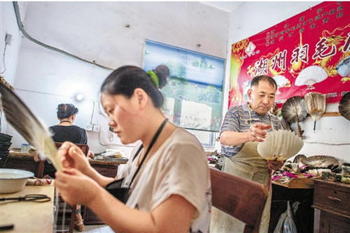 在湖州羽毛扇廠簡陋的車間里,工人在制作羽毛扇