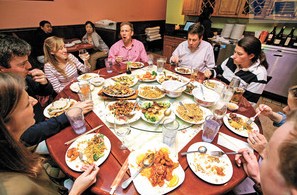 一群老外在中餐館舉行生日派對,吃得不亦樂乎。(美國《星島日報》)