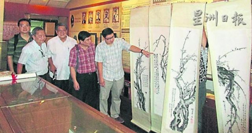 楊金榮講解胡文屏創(chuàng)作的四屏條。(馬來西亞《星洲日報》)