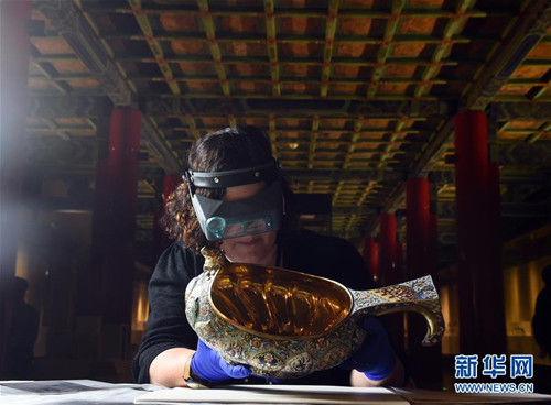 工作人員查看一款準(zhǔn)備展出的畫琺瑯?biāo)⑵?/