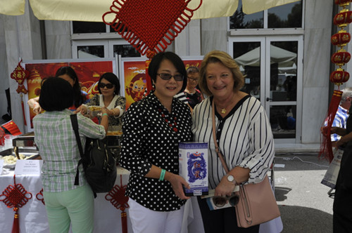 寧懿參贊在中國(guó)展臺(tái)前向希臘總統(tǒng)夫人贈(zèng)送禮品(法國(guó)《歐洲時(shí)報(bào)》/蘇珊娜