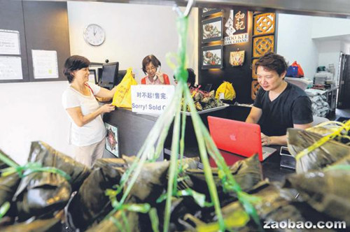 和記肉粽去年底設(shè)立網(wǎng)站讓顧客上網(wǎng)預(yù)訂粽子,少東周崇青(右)希望通過這項(xiàng)服務(wù)吸引年輕顧客群(新加坡《聯(lián)合早報(bào)》/謝智揚(yáng)