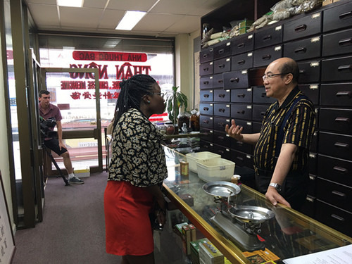 澳洲全國中醫(yī)藥針灸學(xué)會聯(lián)合會會長林子強(右)向訪客介紹(澳大利亞《澳洲網(wǎng)》)