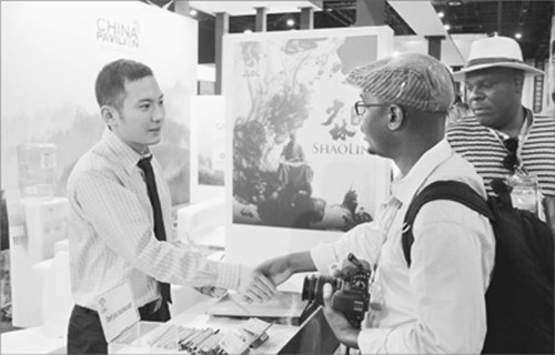 非洲客商向中國企業(yè)展臺工作人員咨詢合作事宜。(李志偉