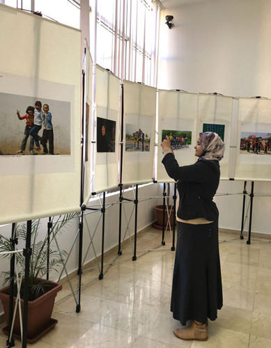 中國僑網(wǎng)一位摩洛哥婦女仔細觀看攝影作品