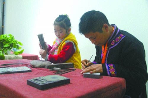 中國僑網(wǎng)非遺傳人胡楊與女兒胡芷祎展示沅洲石雕技藝