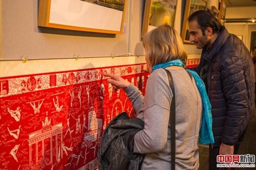 中國僑網(wǎng)參觀民眾細(xì)細(xì)品味長達(dá)29米的世界教科文組織非物質(zhì)文化遺產(chǎn)名作——“從雅典到北京”。