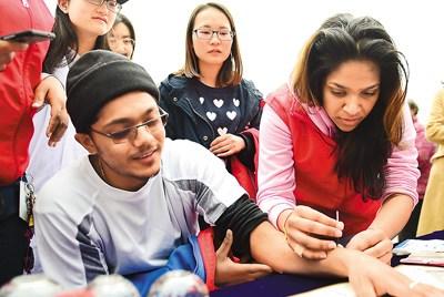 中國僑網(wǎng)圖為來自南非的童詩美(右)在進(jìn)行中醫(yī)針灸治療。(虞俊杰 攝)