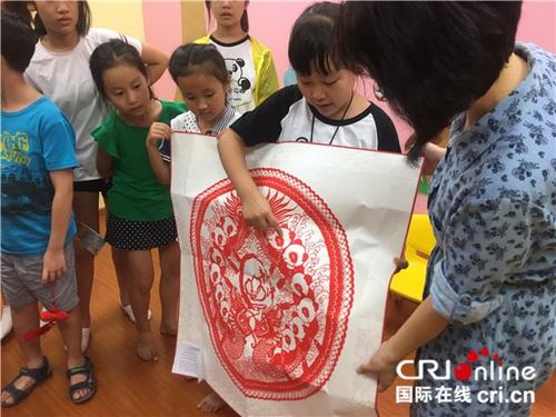 中國僑網(wǎng)熊貓小記者向新加坡北京語文學(xué)校老師贈(zèng)送中國傳統(tǒng)剪紙