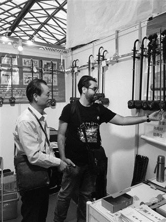 中國(guó)僑網(wǎng)趙軍與美國(guó)友人在觀看二胡。