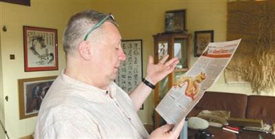 中國(guó)僑網(wǎng)皮特向本報(bào)記者介紹他在當(dāng)?shù)貓?bào)紙上刊發(fā)的一篇文章。(本報(bào)記者 暨佩娟 攝)