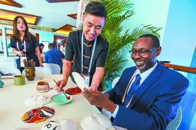 中國僑網(wǎng)《蘇丹視野報(bào)》記者阿布達(dá)拉正在體驗(yàn)京劇臉譜上色。本報(bào)記者 鄧偉攝