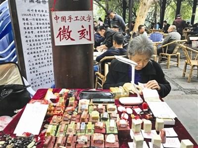 中國僑網(wǎng)劉建英在現(xiàn)場進(jìn)行微刻