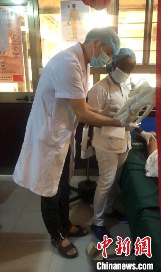 中國(guó)僑網(wǎng)田彤向貝寧學(xué)員講解針灸穴位。受訪者 供圖