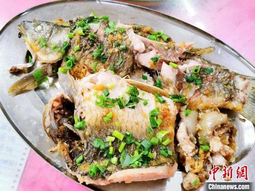 中國僑網(wǎng)焗飯后的鯽魚咸香嫩滑 李曉春攝